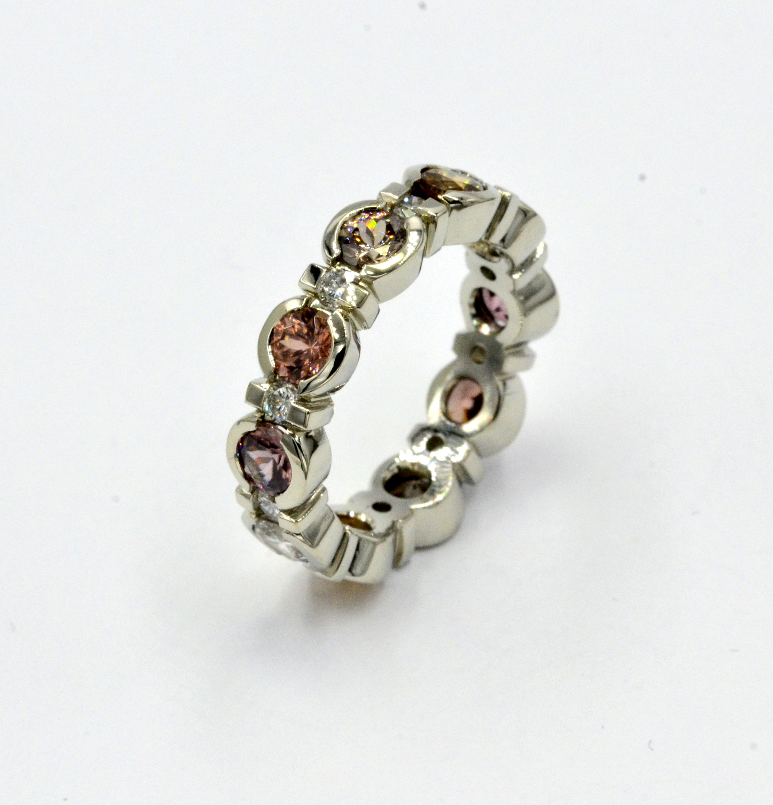 Eternity band with Zircon Gemstones ranging in color from Golden Champagne to shades of Rose Pink Copper. Ring is size 6 + , could be sized up to a 6.25 + max.